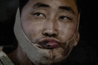 a close up of a man with a bandage on his face making a funny face .