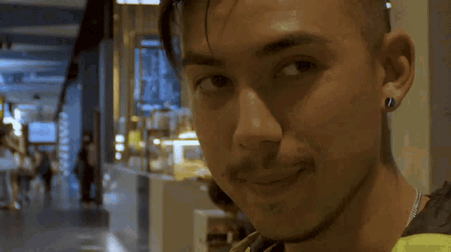 a man with a beard and ear piercings is smiling