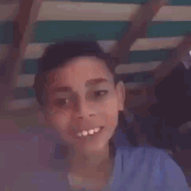 a close up of a young boy 's face with his mouth open .