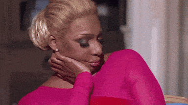 a woman in a pink dress is hugging another woman