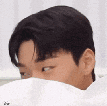 a young man covering his face with a white cloth .