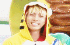 a young man wearing a yellow hoodie with a spongebob hat on his head is smiling .