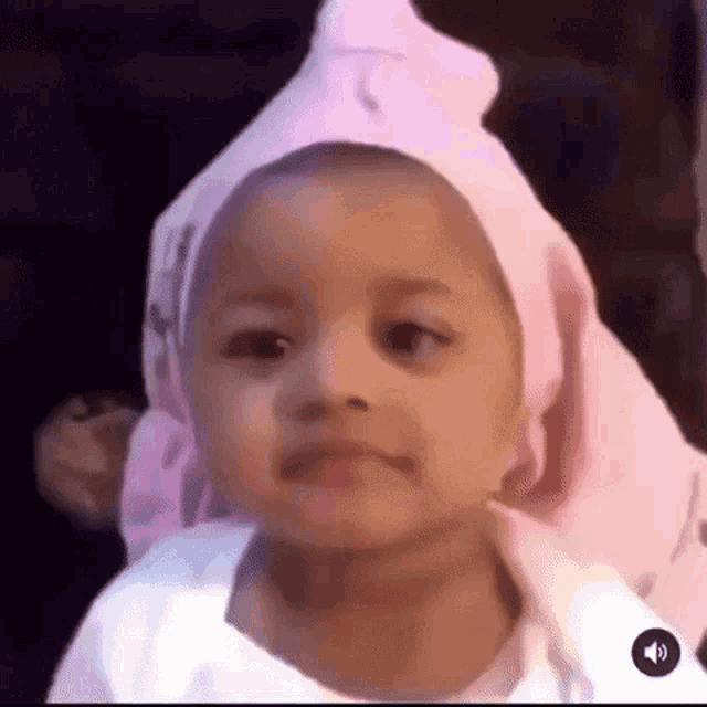 a baby wearing a pink hat and a white shirt .