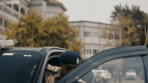 a man in a military uniform is getting out of a police car with the watermark tomsj2006