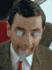 a close up of a man in a suit and tie with tape on his mouth .