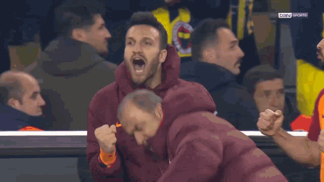 a group of men are watching a soccer game with bein sports