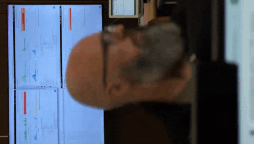 a bald man is looking at a computer screen