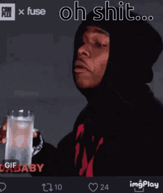 a man in a black hoodie is holding a glass of water with the words oh shit written above him