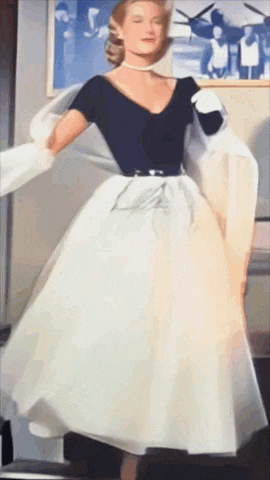 a woman in a black and white dress is dancing in front of a picture