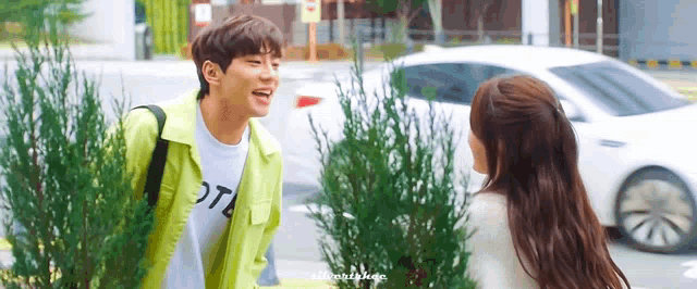 a man and a woman are standing next to each other on a street .