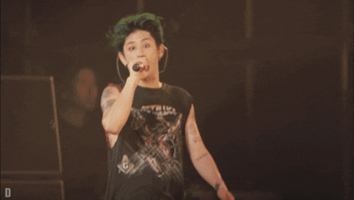 a man singing into a microphone while wearing a black shirt that says metallica
