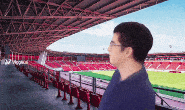 a man stands in a stadium with a viggle.ai logo on the bottom right