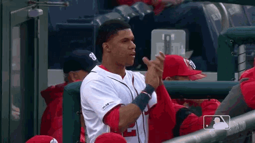 a baseball player with the number 2 on his jersey applauds