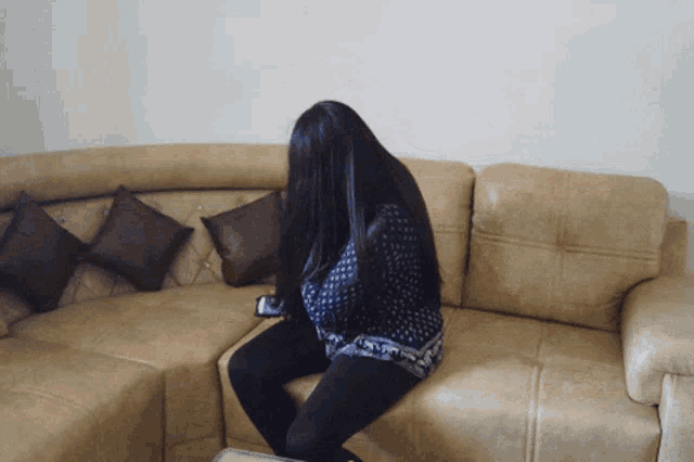 a woman sitting on a couch with her head down