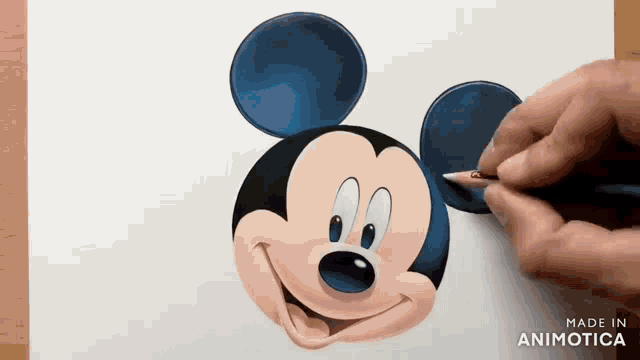 a person is drawing mickey mouse 's face with a pencil