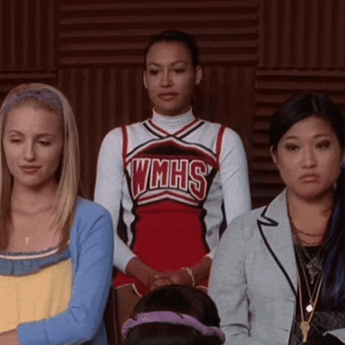 a cheerleader wearing a wmhs uniform sits between two other women