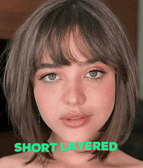 a woman with short hair and bangs is wearing a short layered hairstyle .