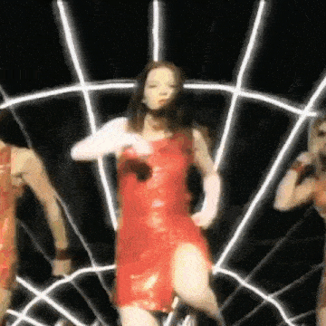 a woman in a red dress is dancing in a dark room .