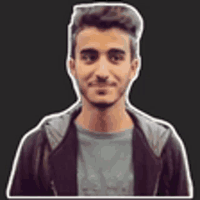 a young man with a beard is wearing a jacket and a t-shirt .