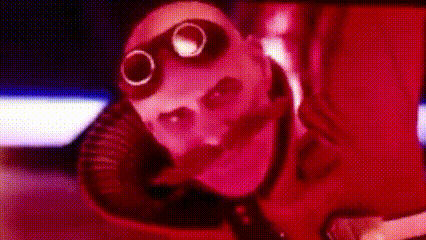 a close up of a person wearing a gas mask in a dark room .