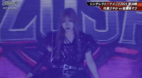 a woman in a black dress stands in front of a screen that says stardom
