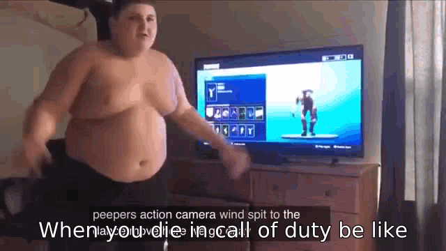 a shirtless man is dancing in front of a television while playing a video game .