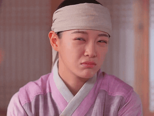 a woman with a bandage on her head is making a face