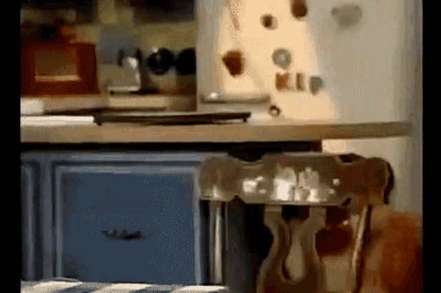 a kitchen counter with a whirlpool refrigerator and a chair