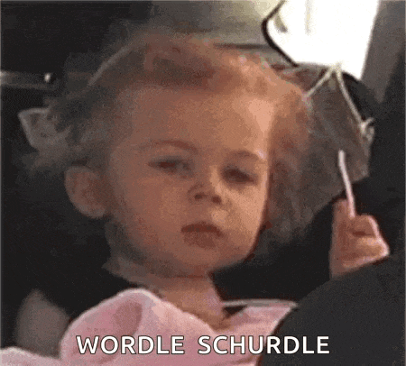 a little girl is sitting in a car seat holding a lollipop and making a face .