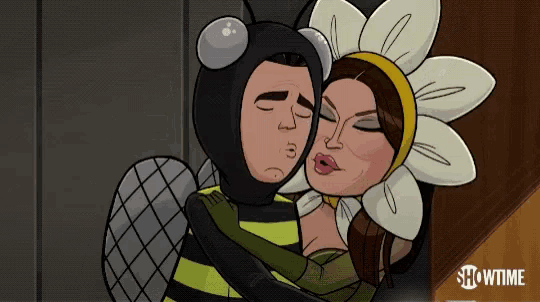 a man in a bee costume kisses a woman in a flower costume on the cheek