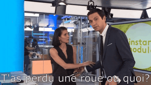 a man in a suit and tie stands next to a woman in a black dress and says tas perdu une roue ou quo