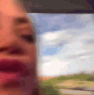 a blurry picture of a person 's face with a picture of a field in the background