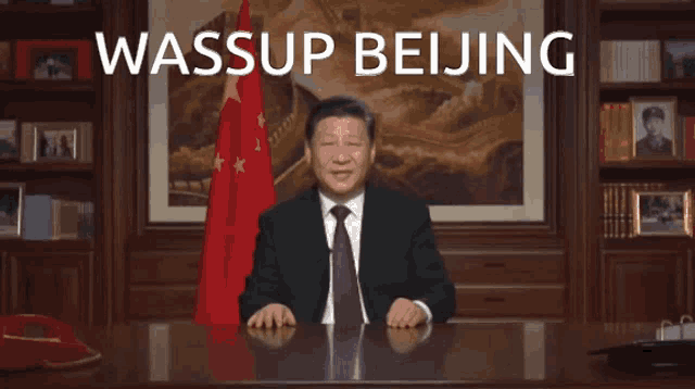 a man sitting at a desk with the words wassup beijing on the bottom