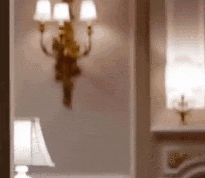 a lamp is sitting in front of a wall with a light on it .