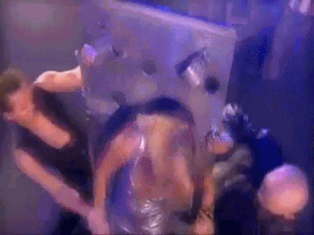 a group of people are standing around a woman in a plastic bag in a dark room .
