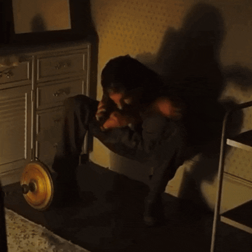 a man is sitting on the floor in a dark room with a door knob in the foreground