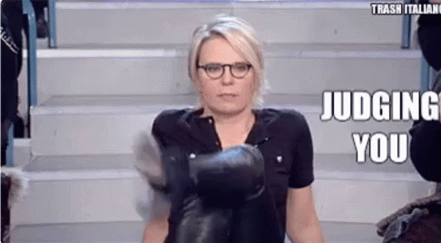 a woman wearing boxing gloves is sitting on a set of stairs and making a funny face .