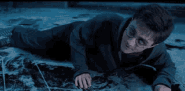 harry potter is laying on the floor with a wand