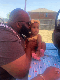 a man with a beard is kissing a baby girl on the cheek