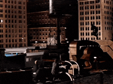 a man is standing on top of a building in the dark