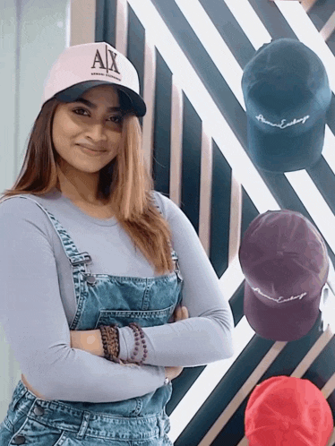 a woman wearing overalls and a hat that says ax on it