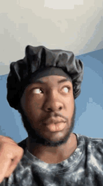 a man with a beard is wearing a hat and looking up .