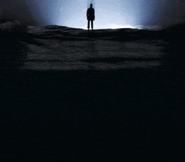 a man stands in front of a large x