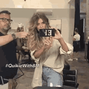 a woman is taking a picture of herself in a mirror with a phone with the number 13 on it .