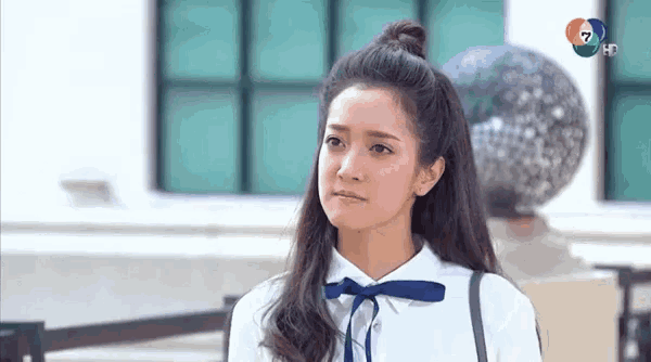 a woman in a white shirt with a blue bow on her neck .