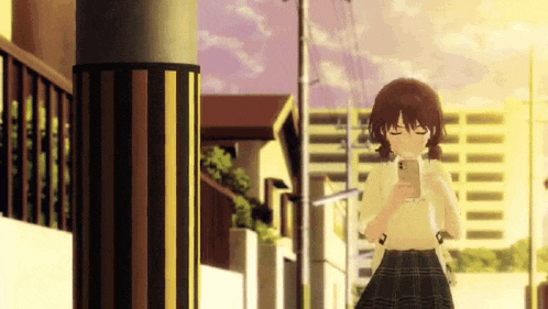a girl in a plaid skirt is walking down a street while looking at her phone .