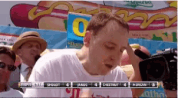 a man is eating a hot dog at a hot dog eating contest