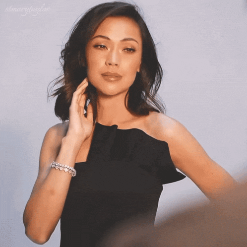 a woman wearing a black dress and a bracelet with the name stmarytaylor on the bottom right