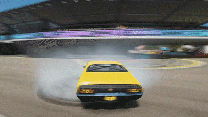 a yellow car is drifting on a track with smoke coming out of it .