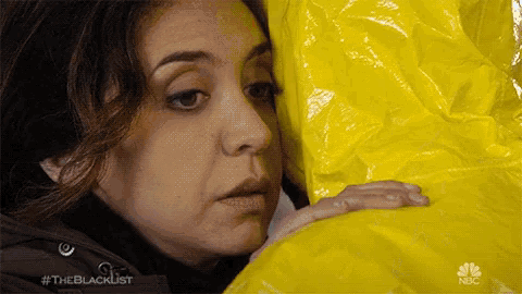 a woman is hugging a yellow bag that says nbc